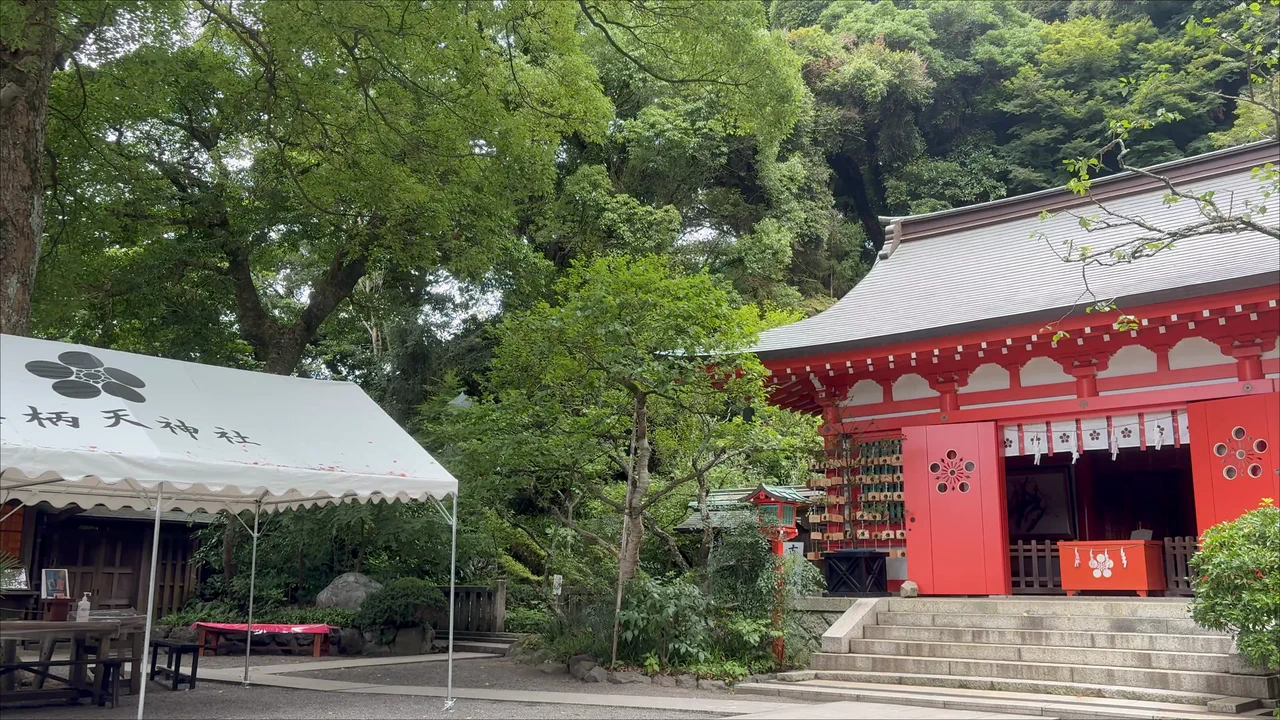 The vermilion worship hall of Egara Tenjin Shrine surrounded by green trees