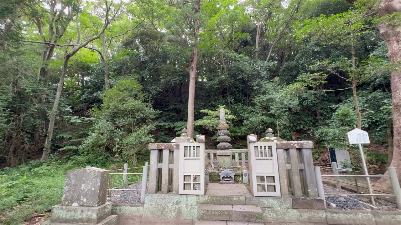 The stone pagoda said to mark Minamoto no Yoritomo's Grave, surrounded by trees above a stone staircase